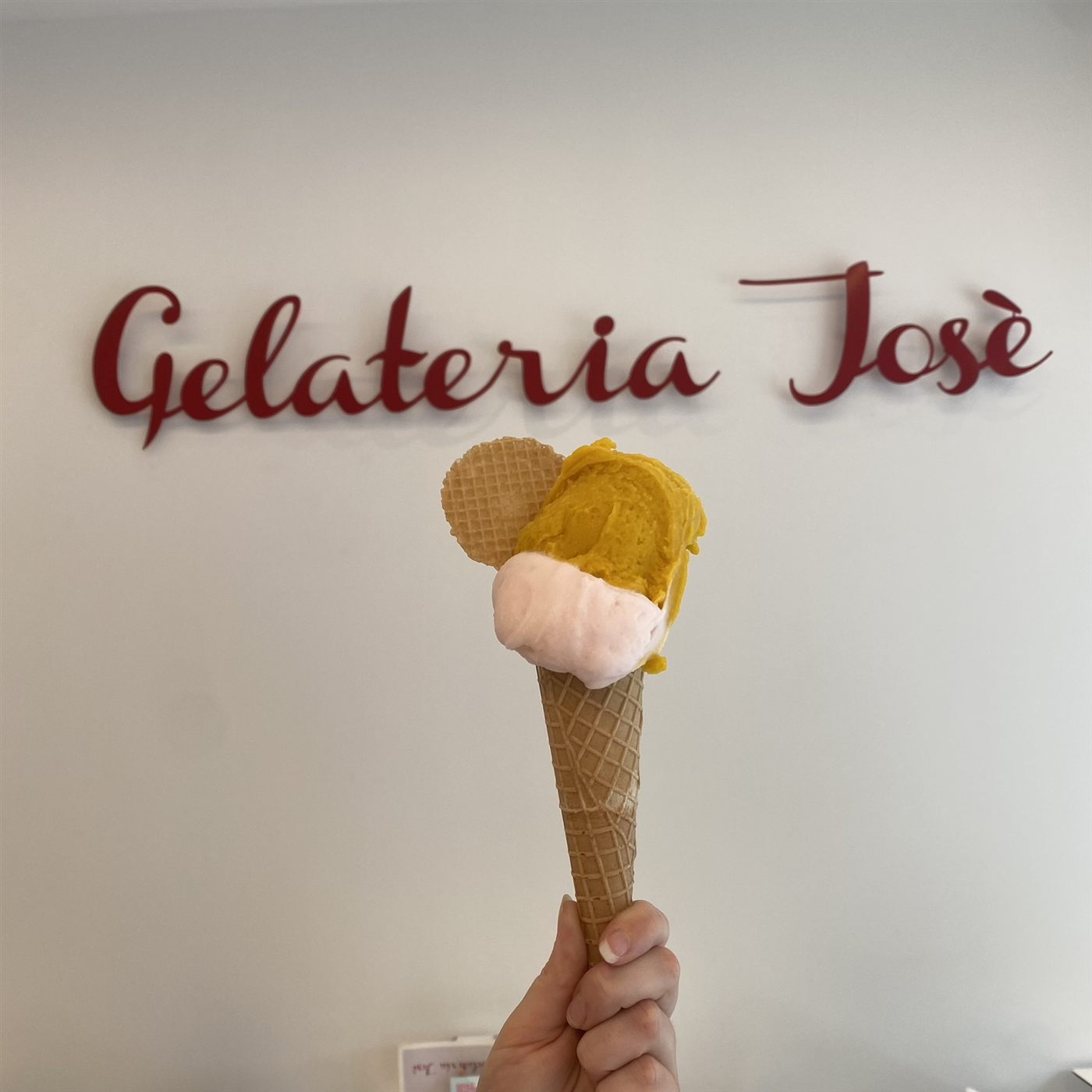 Un cono con gelato giallo e rosa